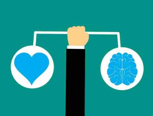  a hand holding the balance between heart and brain