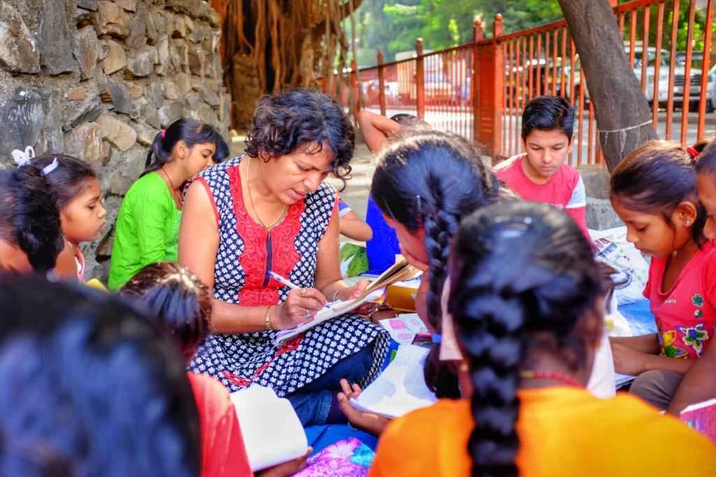 Teacher teaching underprivileged students on the street