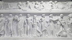 A marble relief depicting people and animals displayed in a museum, showcasing intricate artistry and historical significance.