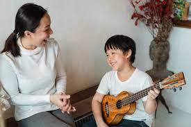 mother and son playing the ukulele