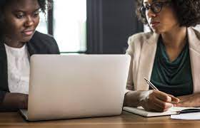 two women working with a laptop
