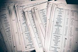 A stack of papers with a pen resting on the top, ready for writing or signing documents.