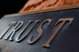 A plaque with the word "trust" engraved on it.