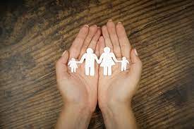 A person holding paper cutouts of a family, symbolizing unity and love.