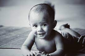 Baby playing with toy on floor.