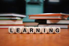 Learning word on wooden table surrounded by books