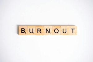 Scrabble tiles spell out "burnout" - a word representing exhaustion and fatigue.