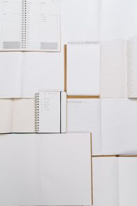 A table displaying an assortment of notebooks and notepads neatly arranged.