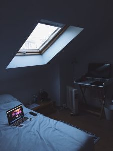 A laptop on a bed in a bedroom, symbolising remote work