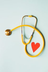 A stethoscope with a heart shape on a blue background, symbolizing medical care and compassion.