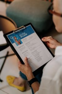 Woman holding a resume on a tablet, preparing for a job interview.