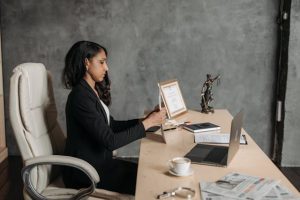 A professional woman in a business suit sitting at a desk with a laptop.