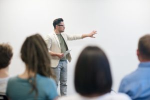A man presenting to a group of people, engaging them with his informative and captivating speech.