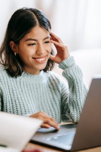Smiling woman working on laptop.