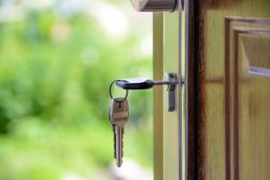 A key hanging on a door handle, symbolizing access or security.